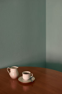 Coffee cup and teapot on a corner table. conceptual image