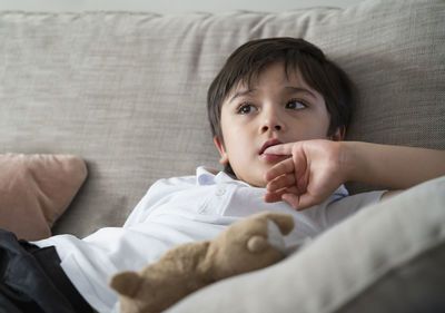 Close-up of cute boy lying on bed at home