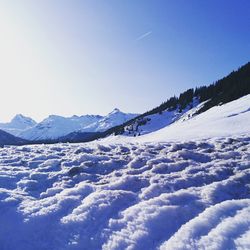 Scenic view of snow covered mountains against clear blue sky