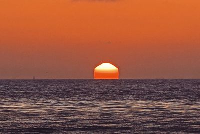 Scenic view of sea against orange sky