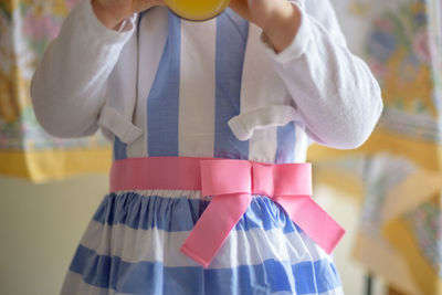 Midsection of girl wearing dress at home