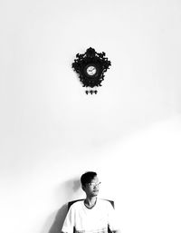 Portrait of young man looking away against wall