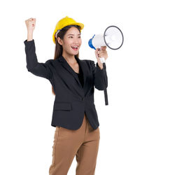 Smiling young woman with arms raised against white background