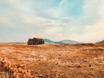 Abandoned built structure on land against sky