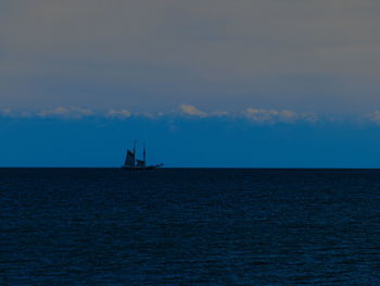 Sailboat sailing on sea against sky