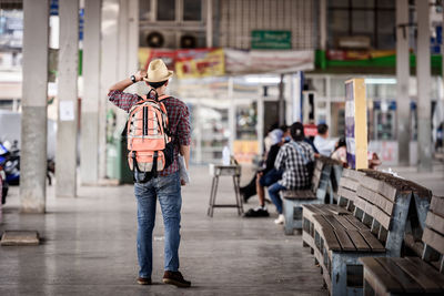 Rear view of man standing on street in city