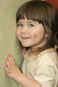 Portrait of cute girl against wall