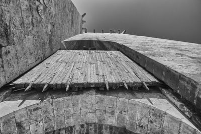 Stone wall by sea against sky