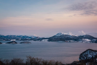 Scenic view of snowcapped mountains against sky during sunset