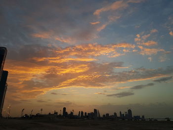 Silhouette buildings against sky during sunset