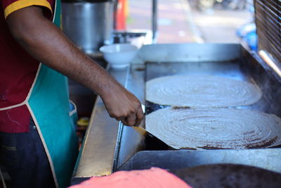 Midsection of man working in kitchen