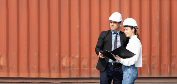 Man looking at camera while standing against wall