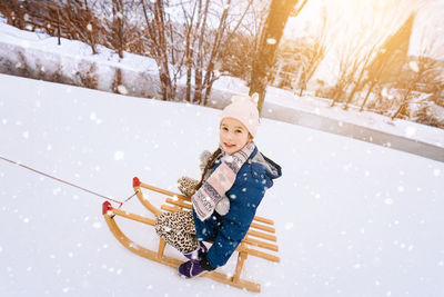 Portrait of cute girl siting on sled