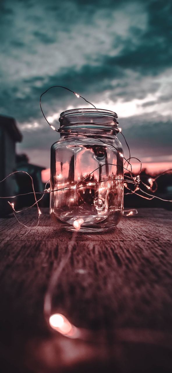 glass - material, table, selective focus, close-up, transparent, illuminated, no people, cloud - sky, nature, sunset, sky, still life, lighting equipment, jar, glass, candle, electricity, glowing, indoors, light, tea light, surface level, luxury