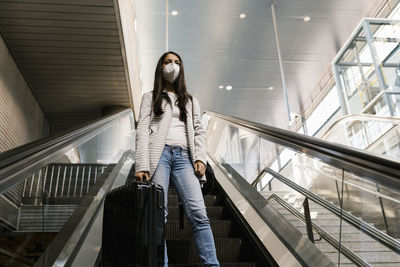 Woman walking on escalator