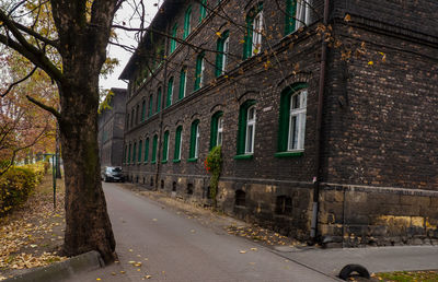 Empty road by buildings in city