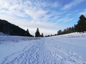 Snow covered field against sky