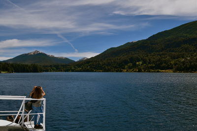 Scenic view of lake by mountain against sky