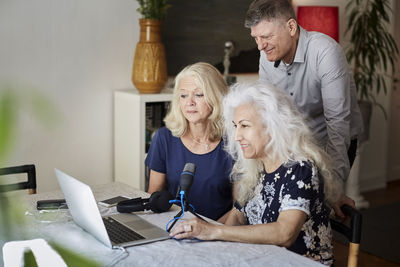 Senior man and women vlogging on laptop a home