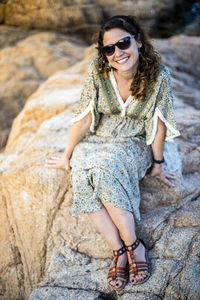 Portrait of a smiling young woman on rock