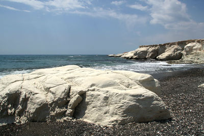 Scenic view of rocks on beach against sky