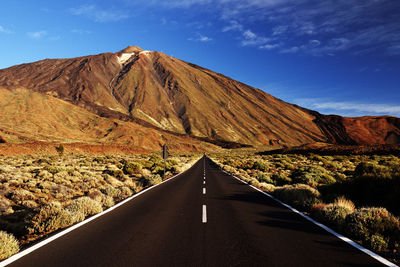 Empty road leading towards mountains against sky at teide national park