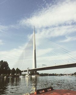 Suspension bridge against cloudy sky