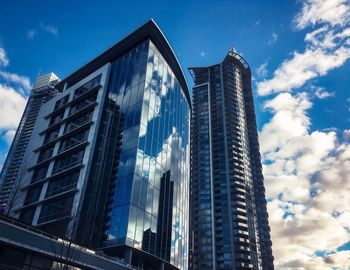 Low angle view of modern buildings against blue sky