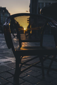 Close-up of empty chairs and table at sidewalk cafe