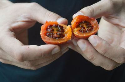 Close-up of hand holding a tamarillo cherry