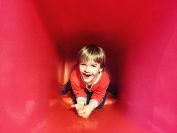 High angle view of happy boy in big red container