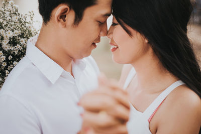 Side view of young couple holding hands outdoors