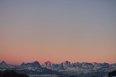 Scenic view of snow covered mountains against sky during sunset