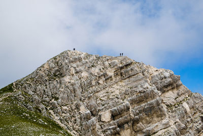 Low angle view of bird on rock against sky in montemonaco, marche italy 