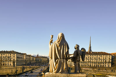 Statue in front of gran madre di dio church with the mole antonelliana in the background
