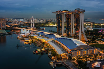 Illuminated buildings in city against sky