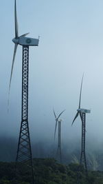 Low angle view of electricity pylon against clear sky