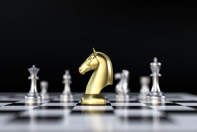 Close-up of chess pieces on table against black background