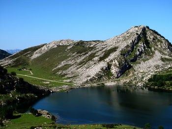 Scenic view of lake and mountains against clear blue sky
