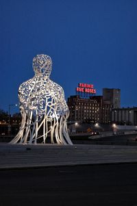 Low angle view of illuminated lighting equipment against clear sky at night