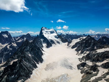 Scenic view of snowcapped mountains against blue sky