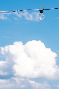 Vintage light bulb with blue sky and white clouds on background. electricity concept. earth hour