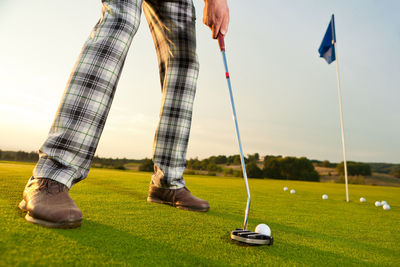 Low section of man standing on golf course