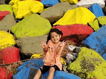 Full length portrait of smiling woman on rock