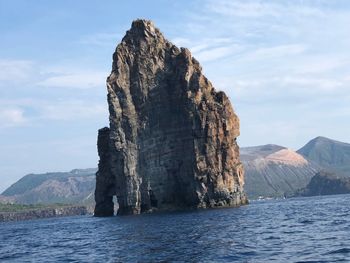 Rock formations by sea against sky