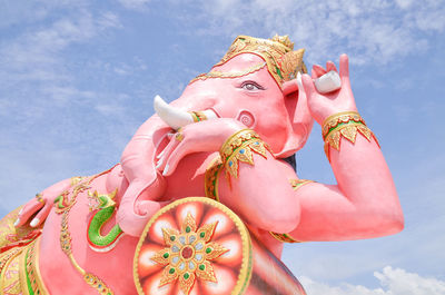 Low angle view of woman with pink flowers against sky