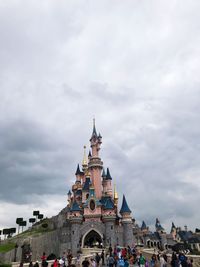 View of buildings in city against cloudy sky