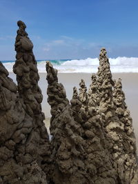 Low angle view of sand formation against sea