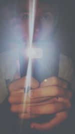 Cropped image of hand holding illuminated lamp