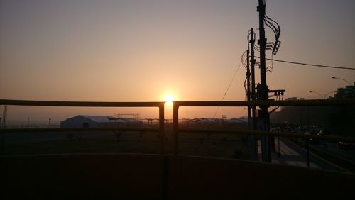 Silhouette electricity pylon against sky during sunset